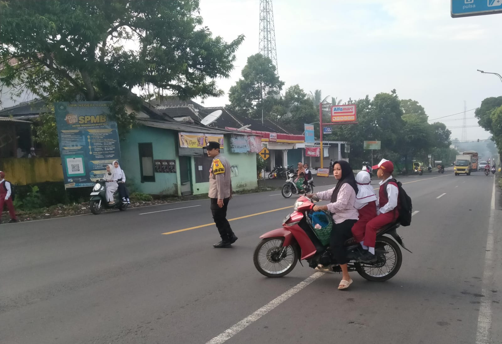 Personil Polsek Ranuyoso Bantu Seberangkan Pelajar di Jam Sibuk