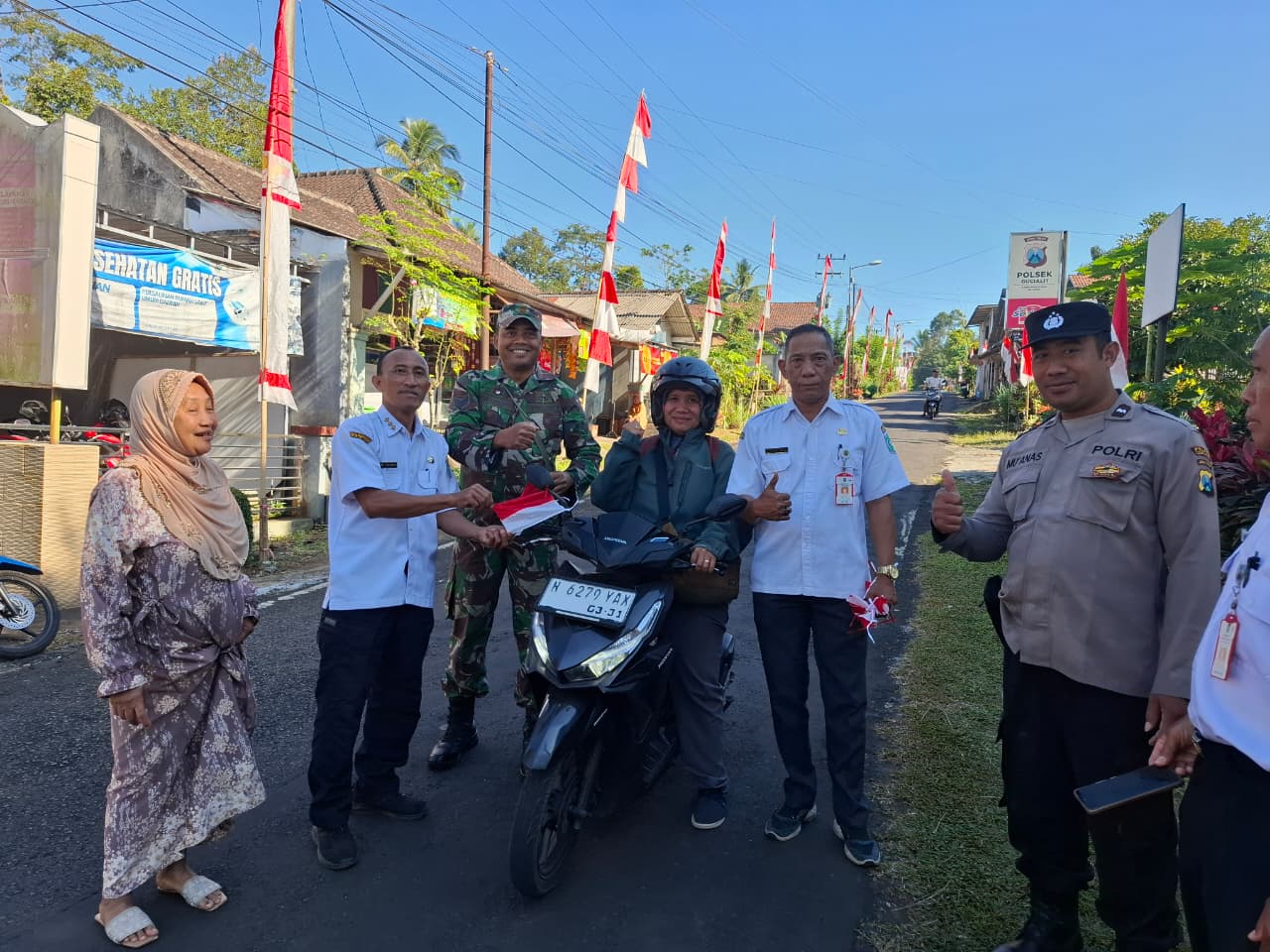 Semarakkan HUT RI, Polsek Gucialit Bersama Muspika Bagikan Bendera Merah Putih kepada Pengendara